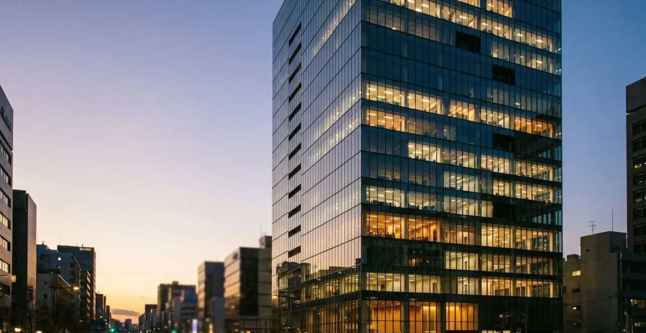 Contemporary glass office building with empty and occupied floors showing hybrid work reality