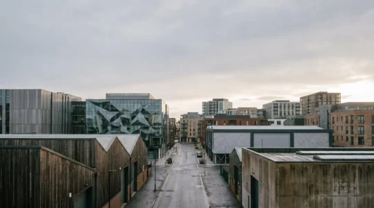 Modern UK commercial property skyline showcasing diverse sector buildings including logistics warehouses and office towers under natural light