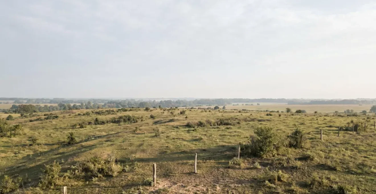 Aerial perspective of undeveloped rural land plot with visible boundaries and natural landscape showing investment potential